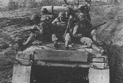 Infantrymen mounted on medium tank, M4A1.