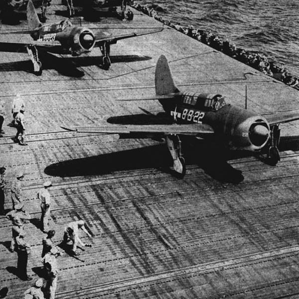 Helldivers on a carrier roll forward to take off.