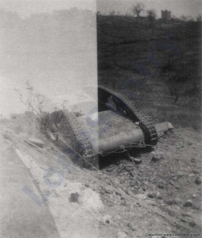 A double exposure showing an overturned Italian tank. The gun barrel can be seen protruding from underneath.