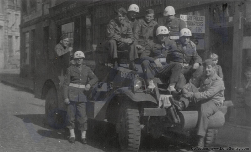 A group of Military Police from an unknown unit pose on the hood of an M3 Scout Car.