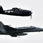 F6F Hellcat flies alongside an F/A-18C Hornet assigned to the Rough Raiders of Strike Fighter Squadron 125