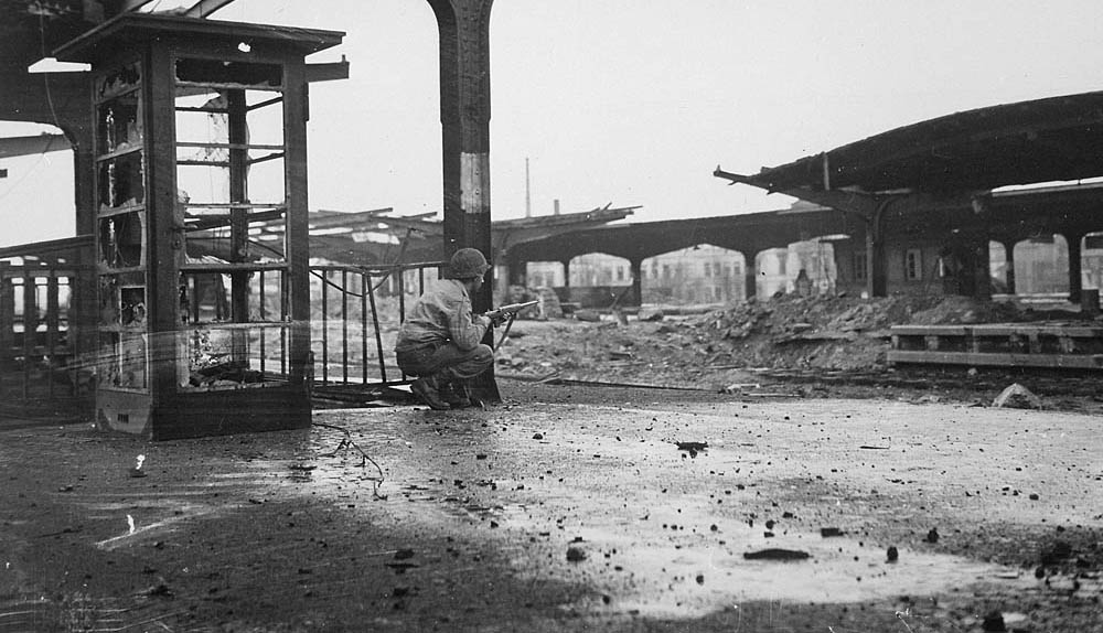 A U.S. infantryman takes cover in the railroad station of Hamm, Germany, April 1945. (U.S. Signal Corps Photograph.)