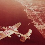 A 12th BG North American B-25 Mitchell bomber with "Finito Benito, Next Hirohito" wing markings flying over the Gulf of Naples. (U.S. Air Force Photograph.)