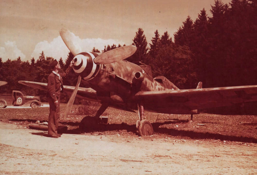 U.S. soldier inspects a German Me 109 fighter abandoned on the airfield at Salzburg, Austria by retreating German forces. (U.S. Air Force Photograph.)