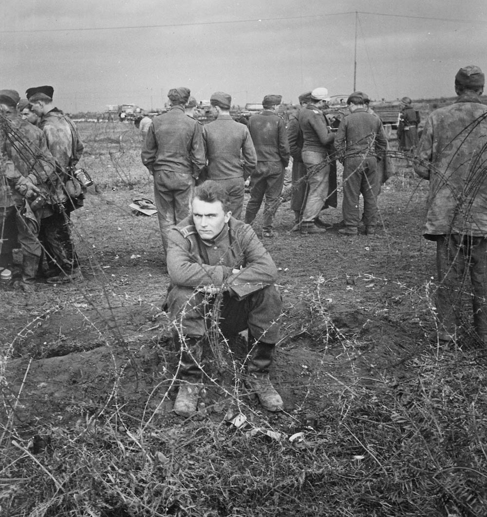 German prisoners, in a variety of uniforms, behind barbed wire in the Anzio beachhead, Italy, February 1944.
