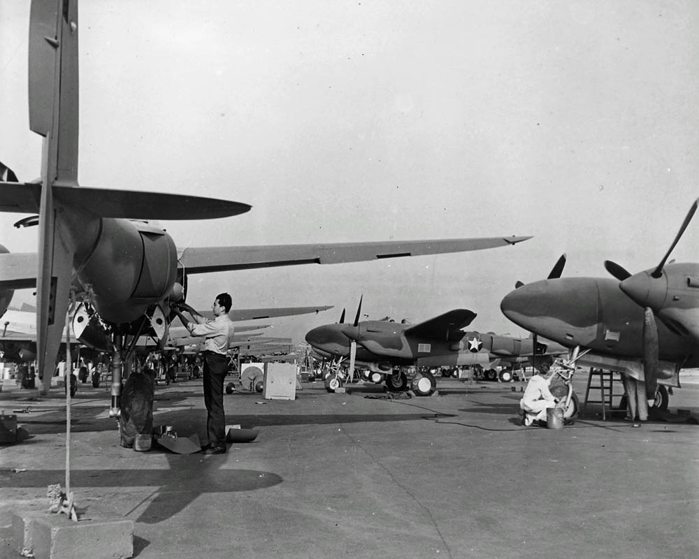 Lockheed P-38 Lightning aircraft receive maintenance and final inspections on the assembly line outside the aircraft plant, circa 1942. (U.S. National Archives)