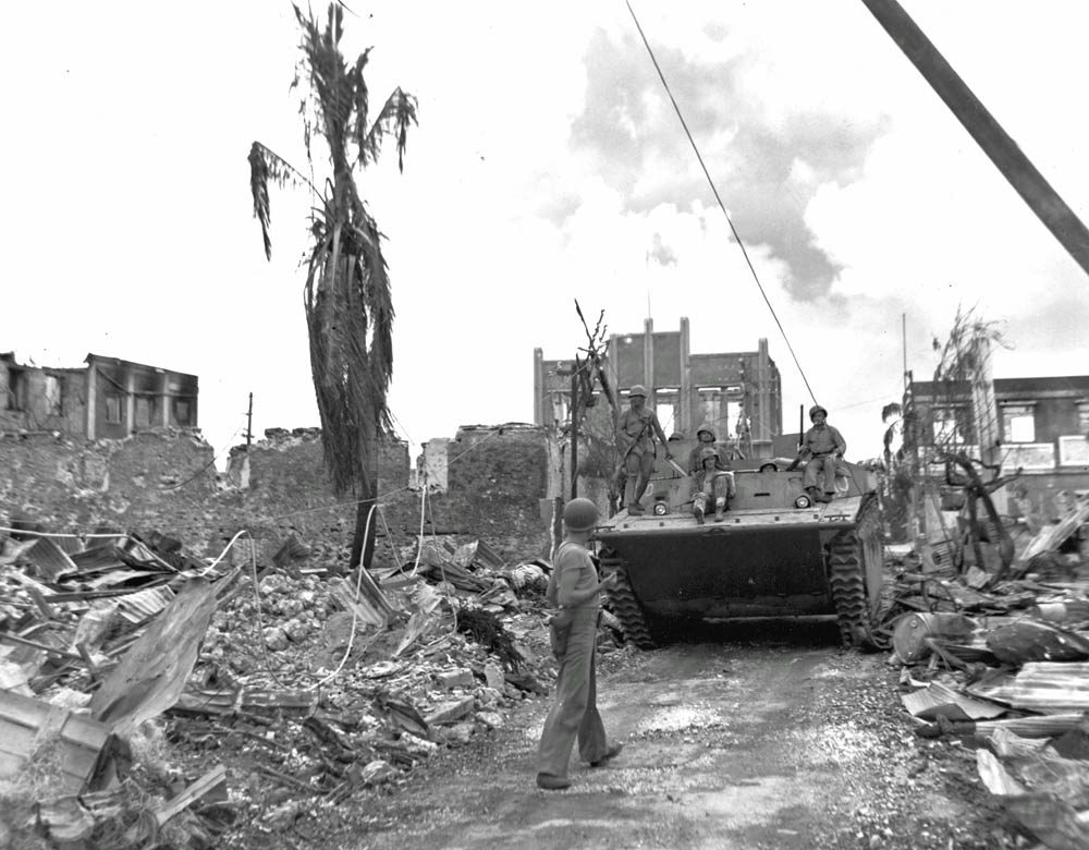 U.S. Marines ride an armored vehicle through Garapan on the island of Saipan in the Mariana Islands, June 1944. (U.S. Marine Corps Photograph.)