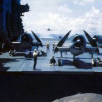 Grumman F6F Hellcat fighters sit with propellers running and wings folded on the flight deck of the aircraft carrier USS Saratoga (CV-3) during World War II. (U.S. Navy Photograph.)