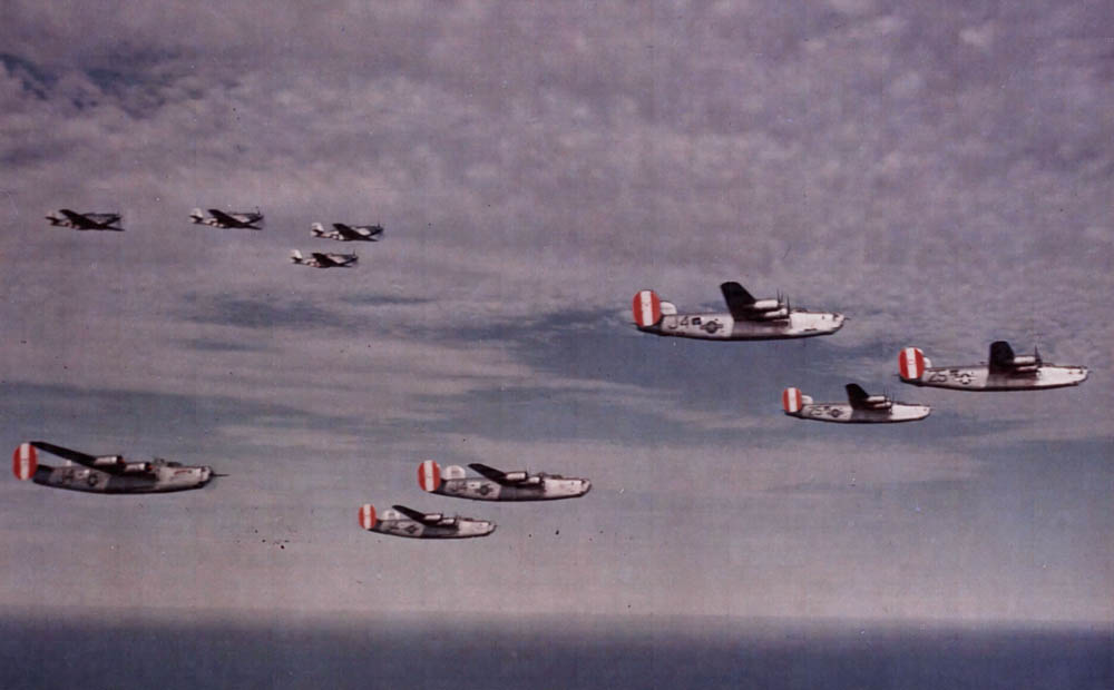 P-51 Mustangs provide cover to a formation of Consolidated B-24 Liberators of the 8th Air Force over England. (U.S. Air Force Photograph.)