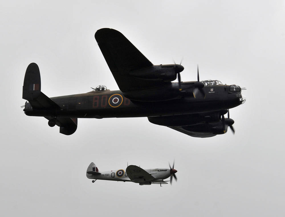 A British Avro Lancaster and Supermarine Spitfire perform The Battle of Britain Memorial Flight for thousands of spectators July 14, 2012, during the Farnborough International Air Show in Farnborough, England. (U.S. Dept. of Defense Photo by Tech. Sgt. Lee Osberry.)