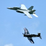 A replica of an F-4E Corsair aircraft flies alongside an F/A-18F Super Hornet during a Centennial of Naval Aviation tribute at the N’awlins Air Show. The air show celebrated the Centennial of Naval Aviation and featured a performance by the U.S. Navy flight demonstration squadron, the Blue Angels. (U.S. Dept. of Defense Photograph by PO1 John Paul Curtis.)
