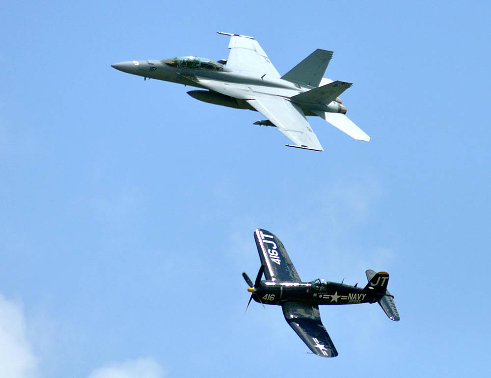 A replica of an F-4E Corsair aircraft flies alongside an F/A-18F Super Hornet during a Centennial of Naval Aviation tribute at the N’awlins Air Show. The air show celebrated the Centennial of Naval Aviation and featured a performance by the U.S. Navy flight demonstration squadron, the Blue Angels. (U.S. Dept. of Defense Photograph by PO1 John Paul Curtis.)