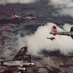 A lone P-51 Mustang fighter flies with a formation of B-17 Flying Fortress bombers over England. (U.S. Air Force Photograph.)