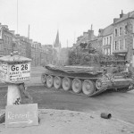 A Cromwell tank from the 2nd Northamptonshire Yeomanry, 11th Armoured Division drives through Vassy, France in August 1944. (Imperial War Museum Photograph.)