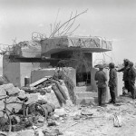 Allied troops examines a knocked-out German bunker on Gold Beach, June 1944. (Imperial War Museum Photograph.)