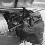 An armorer loads ammunition in the guns in the nose of a P-38 Lightning fighter. (U.S. Air Force Photograph.)
