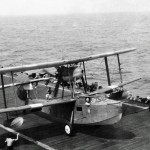 A British Supermarine Walrus flying boat lands the deck of an aircraft carrier in the Indian Ocean (Imperial War Museum Photograph.)