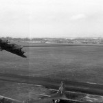A Boeing B-17F Flying Fortress of the 401st Bomb Squadron makes a low level pass over a second parked B-17 of the 324th Bomb Squadron at Bassingbourn, England. (U.S. Air Force Photograph.)