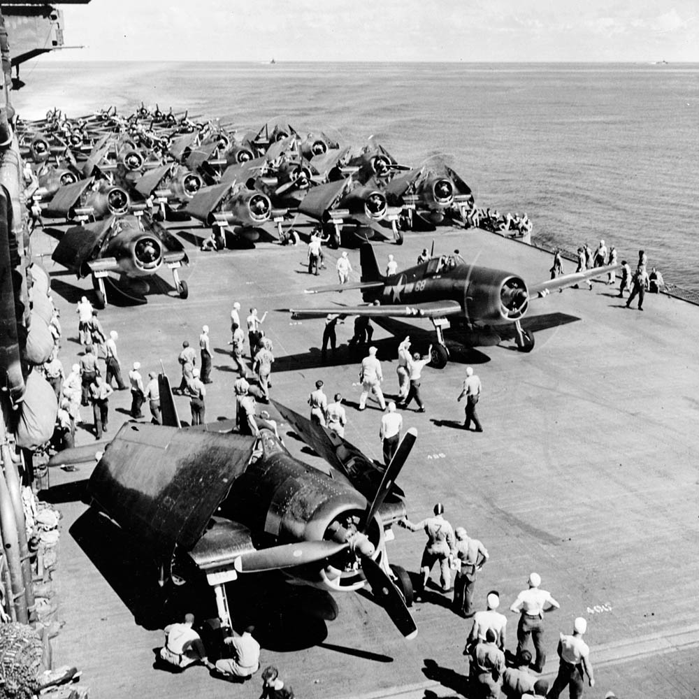 On the crowded flight deck of the aircraft carrier USS Saratoga (CV-3), Grumman F6F-3 Hellcats, Grumman TBF-1 Avengers, and Douglas SBD-5 Dauntless prepare for a strike in November 1943.
