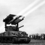 A Calliope rocket launcher mounted on the turret of an M4 Sherman tank of the 14th Armored Division fires a barrage during WWII. (Official US Signal Corps Photograph.)