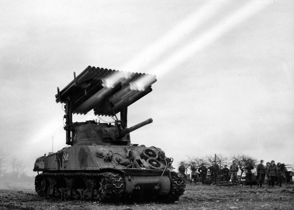 A Calliope rocket launcher mounted on the turret of an M4 Sherman tank of the 14th Armored Division fires a barrage during WWII. (Official US Signal Corps Photograph.)