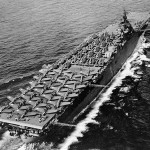 Aircraft carrier USS Essex photographed by a blimp from the U.S. Navy underway in May 1943 with Douglas SBD-5 Dauntless dive bombers, Grumman F6F-3 Hellcat fighters, and Grumman TBF-1 Avenger torpedo planes all parked on the flight deck. (Official U.S. Navy Photograph.)