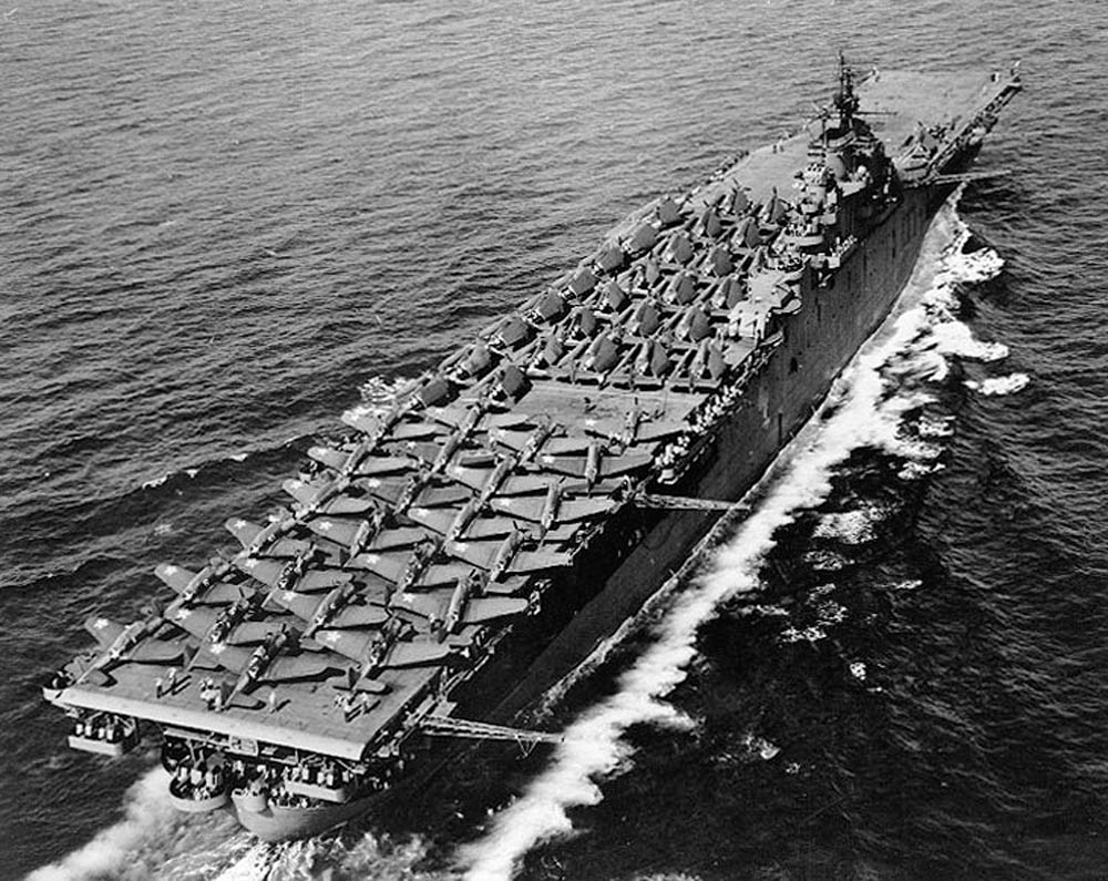 Aircraft carrier USS Essex photographed by a blimp from the U.S. Navy underway in May 1943 with Douglas SBD-5 Dauntless dive bombers, Grumman F6F-3 Hellcat fighters, and Grumman TBF-1 Avenger torpedo planes all parked on the flight deck. (Official U.S. Navy Photograph.)