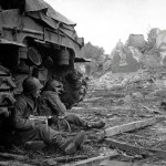 Soldiers of the 36th Armored Infantry Regiment take cover behind an M4 Sherman tank near Düren, Germany, December 1944. (U.S. Army Photograph.)