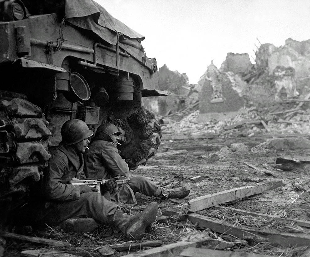 Soldiers of the 36th Armored Infantry Regiment take cover behind an M4 Sherman tank near Düren, Germany, December 1944. (U.S. Army Photograph.)