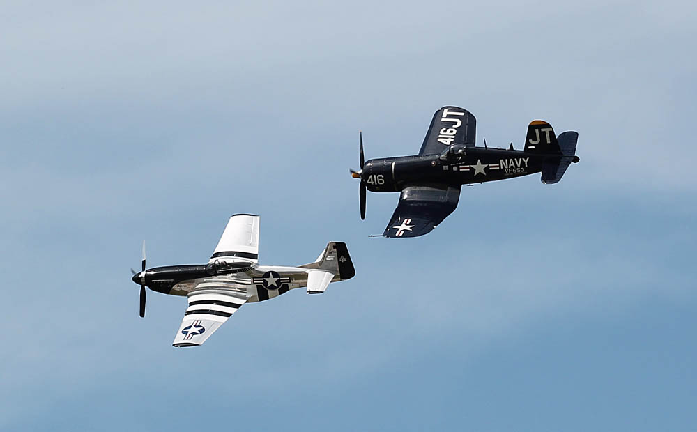 A P-51 Mustang fighter and a F4U Corsair fighter pass over audiences at the Tampa Bay Air Fest at MacDill Air Force Base, Tampa, Fla., on March 20, 2016. U.S. Army Photograph by Capt. Yau-Liong Tsai / Released.
