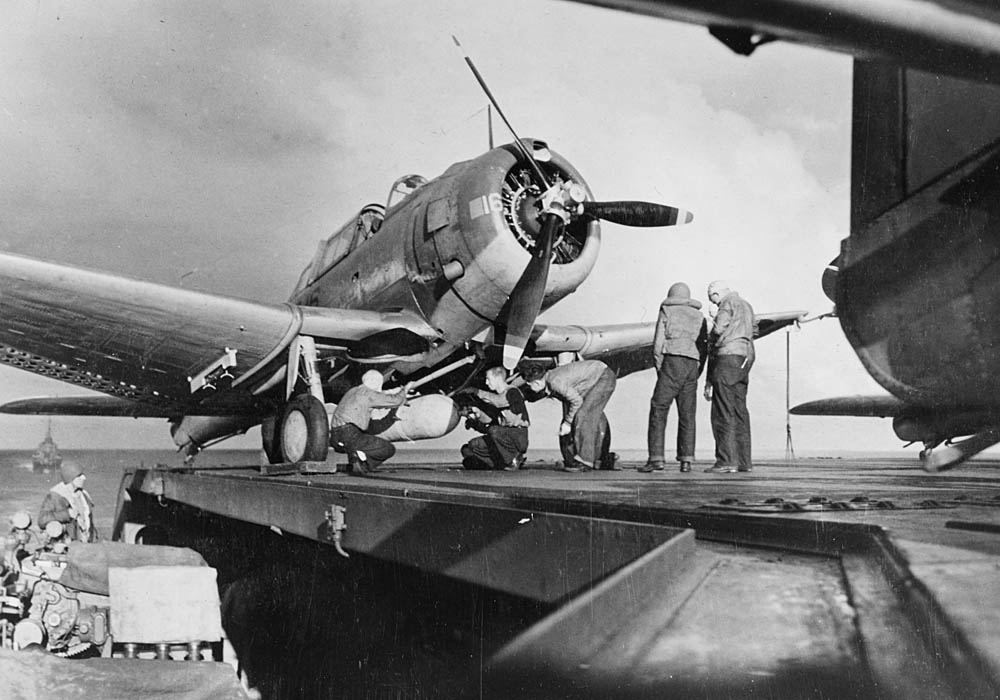 Sailors mount a 1000-pound bomb beneath a Douglas SBD-3 Dauntless on the flight deck of USS Ranger during Operation Torch in November 1942. (U.S. National Archives Photograph.)