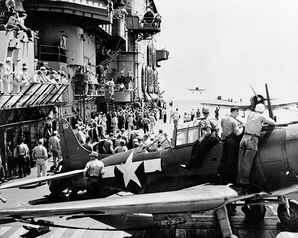 Sailors watch aircraft from the Carrier Air Group 12 (CVG-12) landing on the flight deck of the U.S. Navy aircraft carrier USS Saratoga (CV-3).