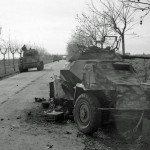 British Sherman tanks pass by a knocked-out German SdKfz 222 light armored car in Italy, January 1944.