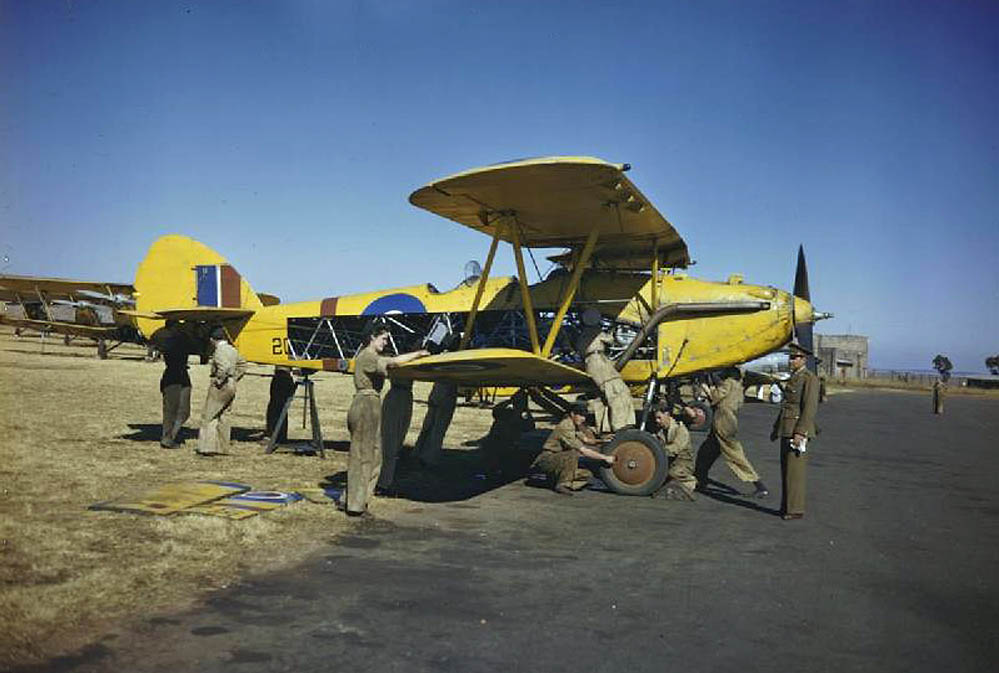 Women's Auxiliary Air Force (WAAF) and RAF trainee ground crew perform maintenance work on a Hawker Hart biplane as part of the Commonwealth Joint Air Training Plan at Waterkloof near Pretoria, South Africa. (Imperial War Museum Photograph.)