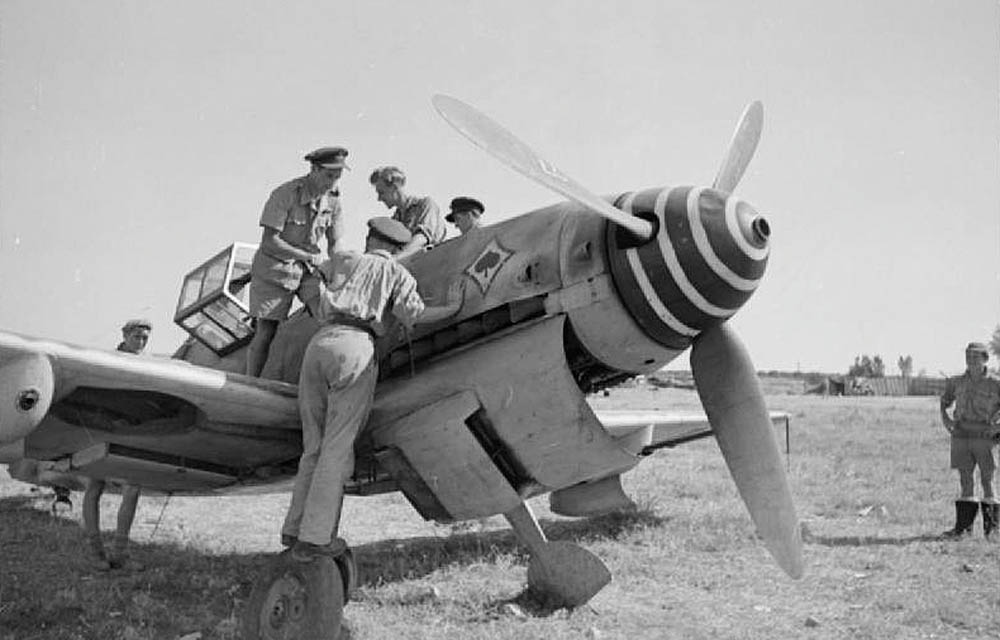 RAF pilots examine an abandoned Messerschmitt Me 109G of JG 53 at Comiso, Sicily in 1943. (Imperial War Museum Photographs.)