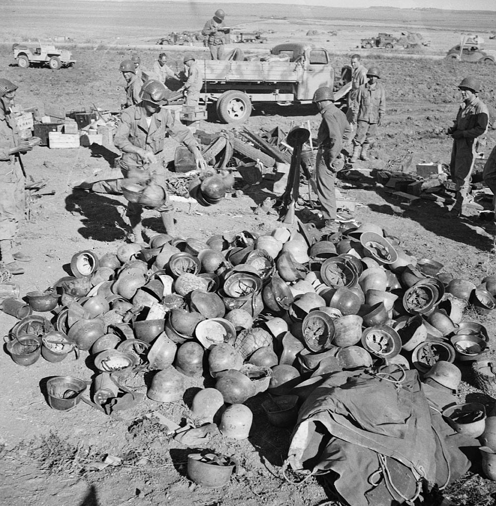 U.S. Army soldiers sort through a pile of German helmets left behind by the 10th and 15th Panzer Divisions after the Axis surrender in Tunisia. (U.S. Library of Congress Photograph.)