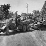 An Allied wrecker pulls a StuG III assault gun from the roadside ditch where the panzer was abandoned in Normandy. (U.S. Air Force Photograph.)