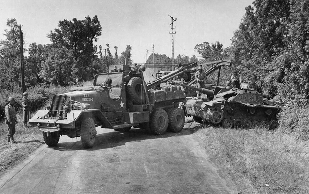 An Allied wrecker pulls a StuG III assault gun from the roadside ditch where the panzer was abandoned in Normandy. (U.S. Air Force Photograph.)