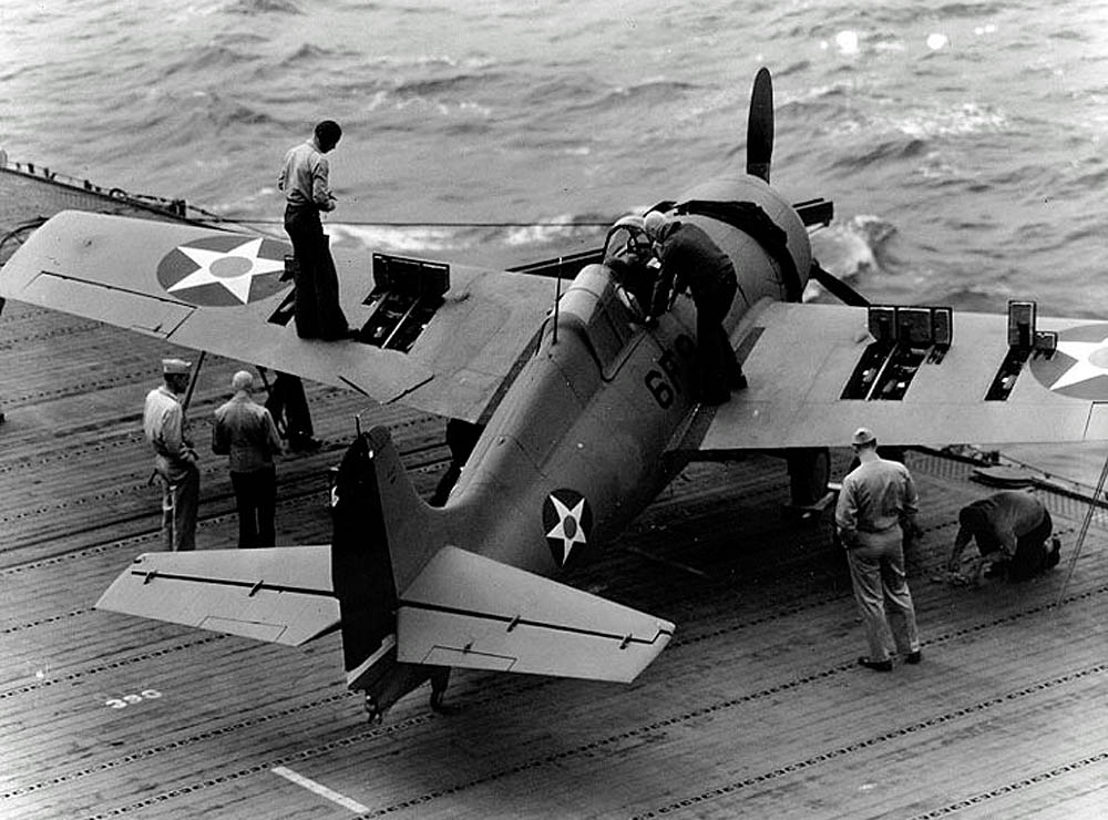 Sailors test the machine guns of a Grumman F4F-4 Wildcat of Fighting Squadron Six (VF-6) on the flight deck of the aircraft carrier USS Enterprise (CV-6) in April 1942. (U.S. Navy Photograph.)