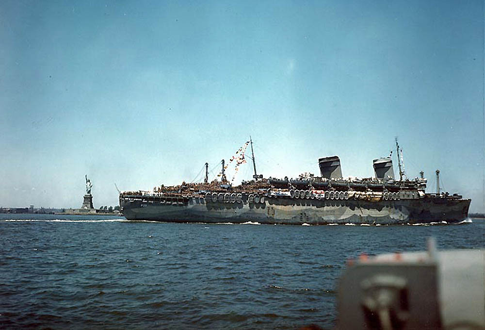 Loaded with troops returning from Europe, USS West Point passes the Statue of Liberty outisde New York City, July 1945. (U.S. Navy Photograph.)