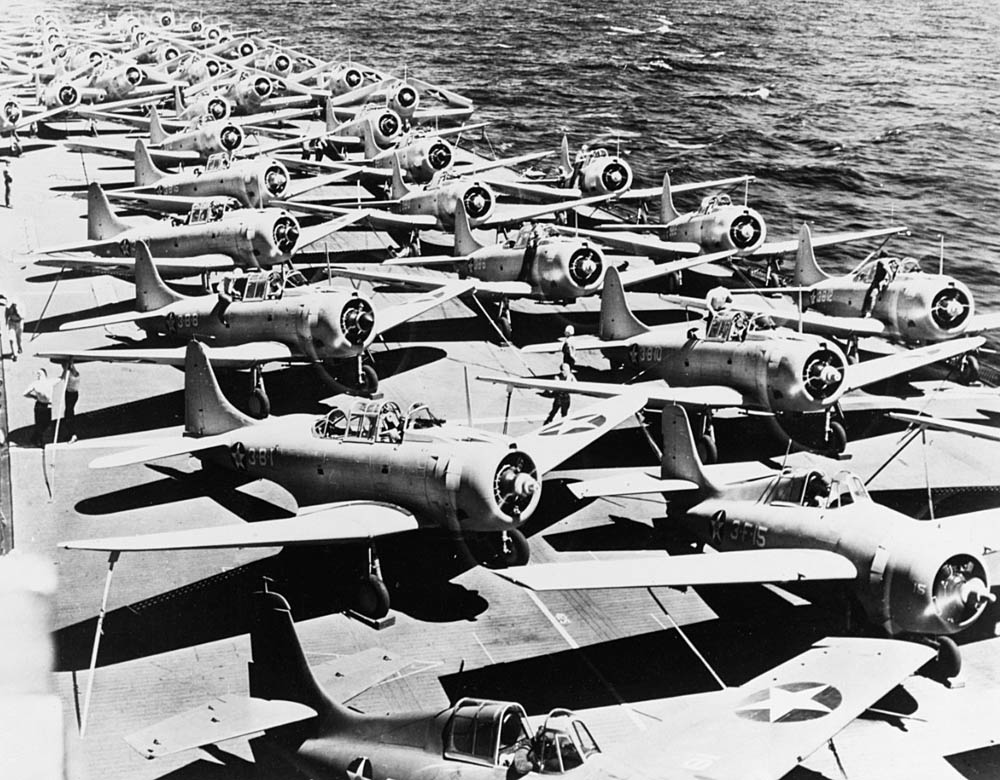 In the foreground, Grumman F4F-3 Wildcats of VF-3, Felix the Cat, are parked on the flight deck of the USS Saratoga. In the background, Douglas SBD-3 Dauntless and Douglas TBD-1 Devastator aircraft are pictured. (U.S. Navy Photograph.)