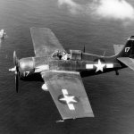 A U.S. Navy FM-2 Wildcat fighter flies a combat air patrol over the escort carrier USS Santee (CVE-29) during the Leyte Invasion in October 1944. (Official U.S. Navy Photograph.)