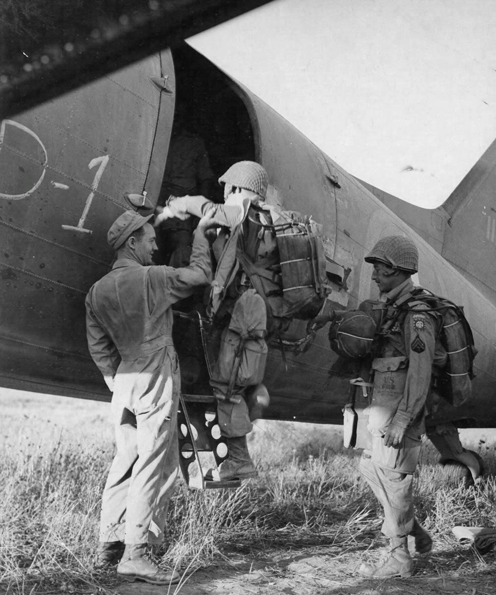 Paratroopers, with 82nd Airborne Division shoulder patches, board a plane on Karouan Airfield, near Sousse, Tunisia. (U.S. Air Force Photograph.)