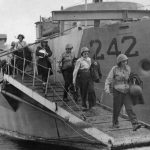The first nurses to arrive on Pantelleria disembark from a landing craft after their voyage from North Africa. (U.S. Air Force Photograph.)