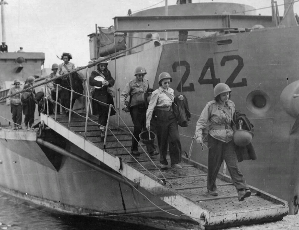 The first nurses to arrive on Pantelleria disembark from a landing craft after their voyage from North Africa. (U.S. Air Force Photograph.)
