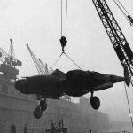 A Lockheed P-38 Lightning fighter is unloaded by crane from a ship at Queens Dock, Liverpool in January 1943. (U.S. Air Force Photograph.)