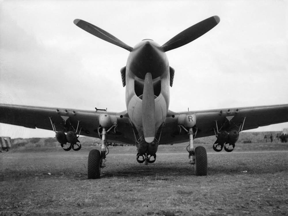 A Curtiss P-40 Kittyhawk of No. 450 Squadron RAAF awais a mission loaded with six 250 lb bombs mounted under the wings and fuselage in North Africa. (Australian War Memorial Photograph.)
