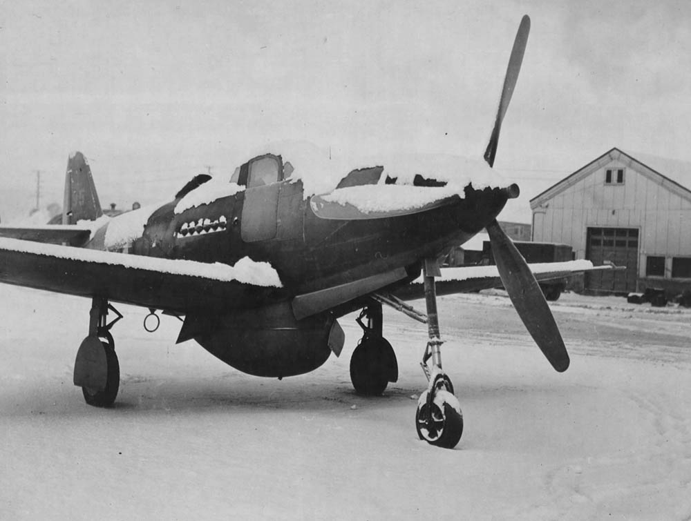 A Bell P-39 Airacobra fighter sits covered in snow at Ladd Field, Alaska in February 1944. (U.S. Air Force Photograph.)