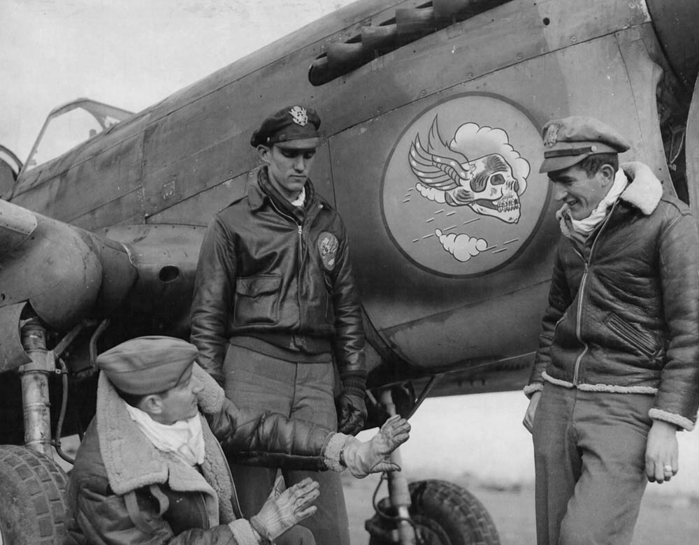 Pilots from the 85th "Flying Skull" Fighter Squadron, 79th Fighter Group discuss air tactics in front of a Curtiss P-40 Warhawk fighter. (U.S. Air Force Photograph.)