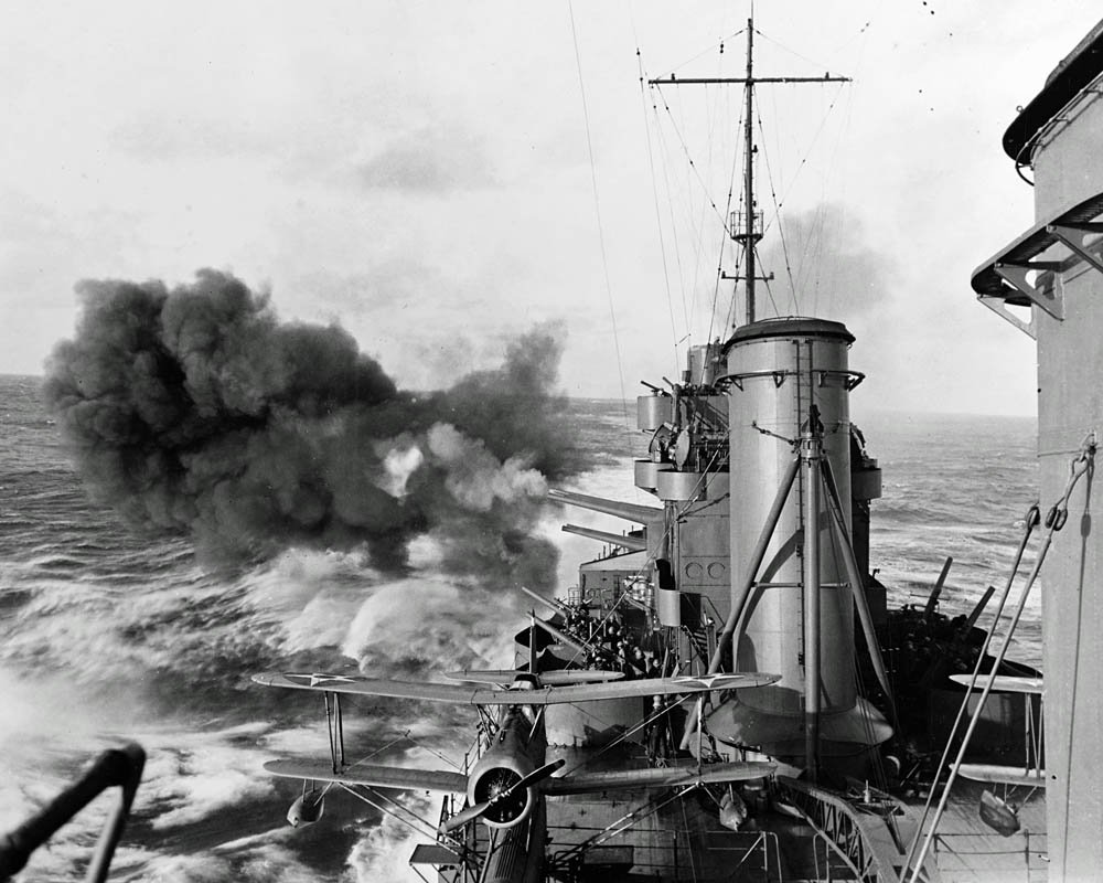 The heavy cruiser USS Salt Lake City (CA-25) fires her 8 inch/55 caliber guns while bombarding a Pacific island in February 1942. (U.S. Navy Photograph.)